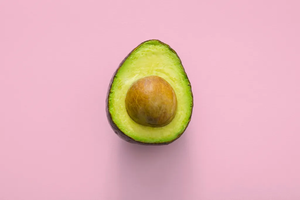 A ripe avocado sliced in half