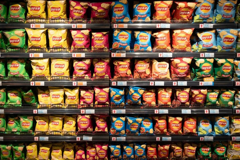 Store shelves stocked with bags of chips and packaged snacks